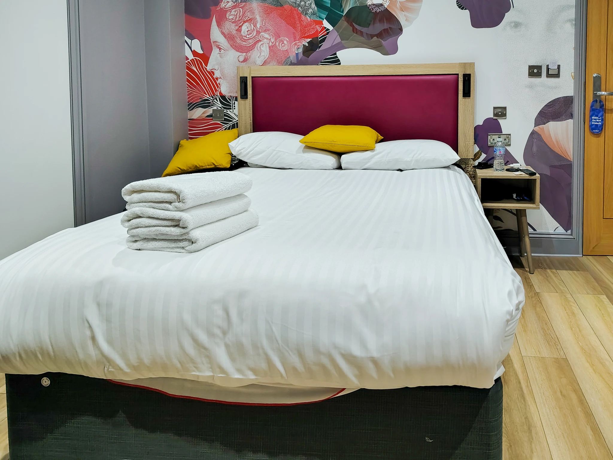 Czysty i komfortowy pokój hotelowy z podwójnym łóżkiem i dekoracyjnymi poduszkami w Comfort Inn Edgware Road w Londynie.