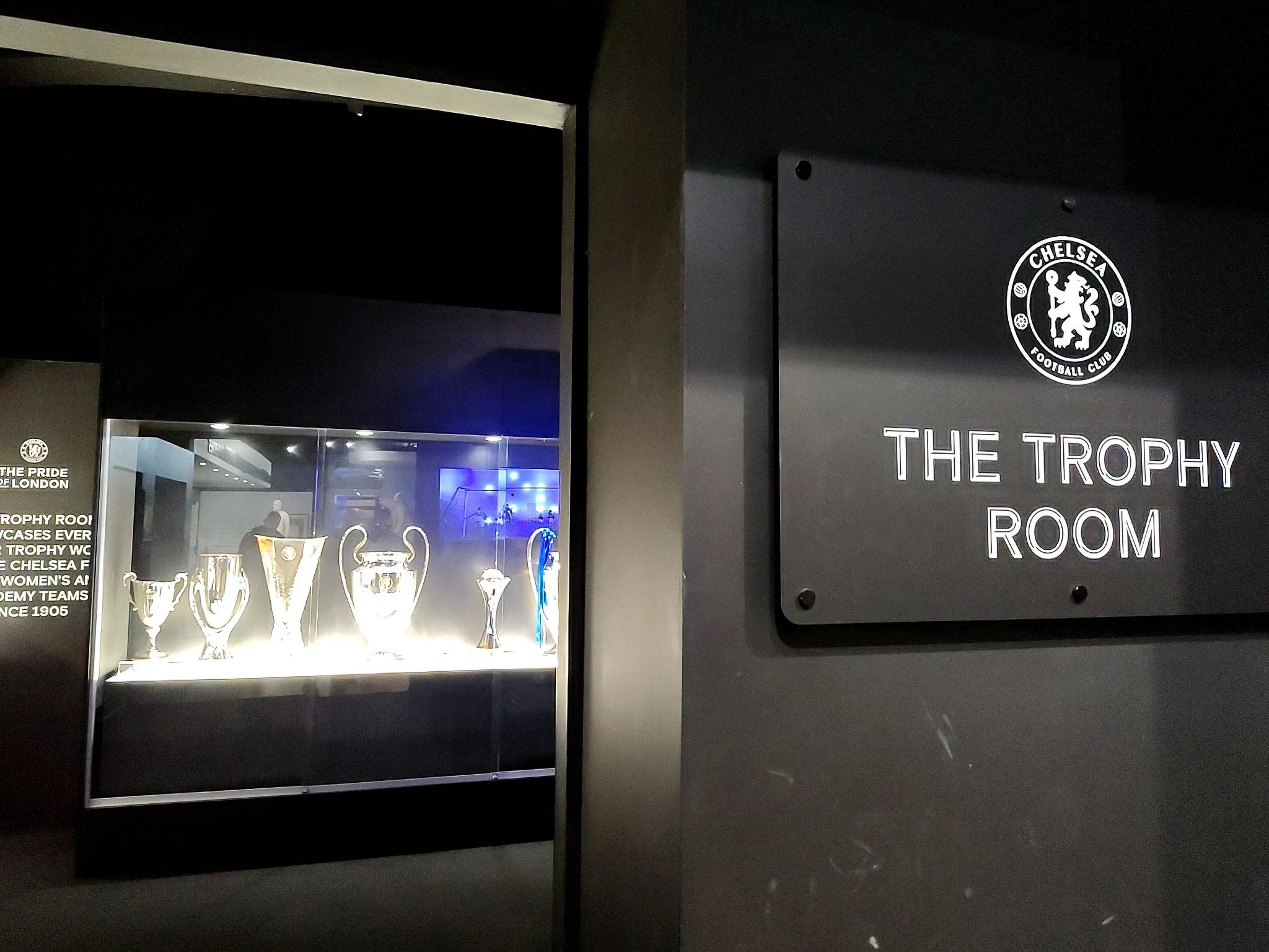 Wejście do klubowej sali trofeów z gablotą pucharów zdobytych przez drużyny Chelsea FC.