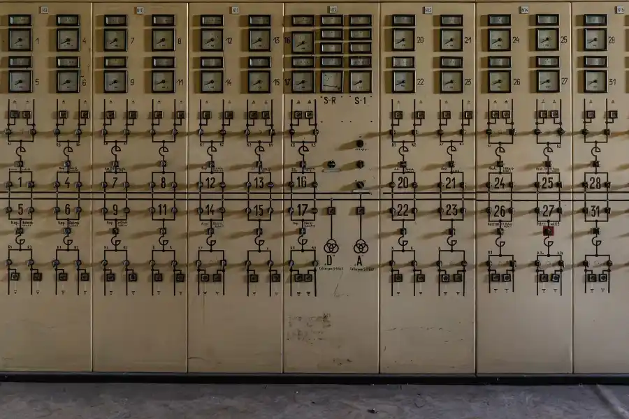 Analogowa tablica sterownicza z miernikami w industrialnym obiekcie